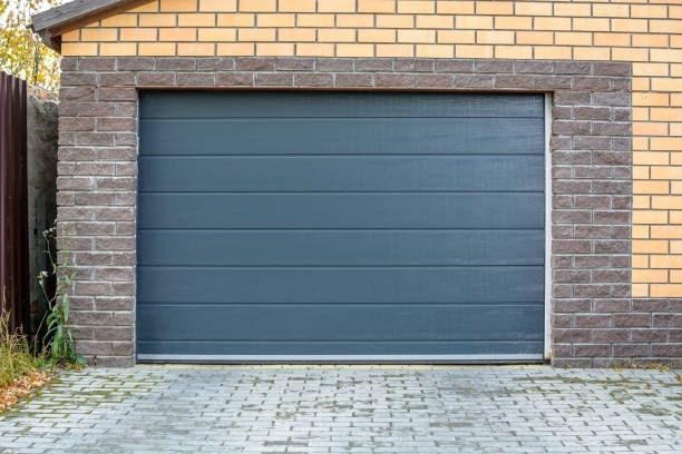 A garage door is open in front of a brick building.