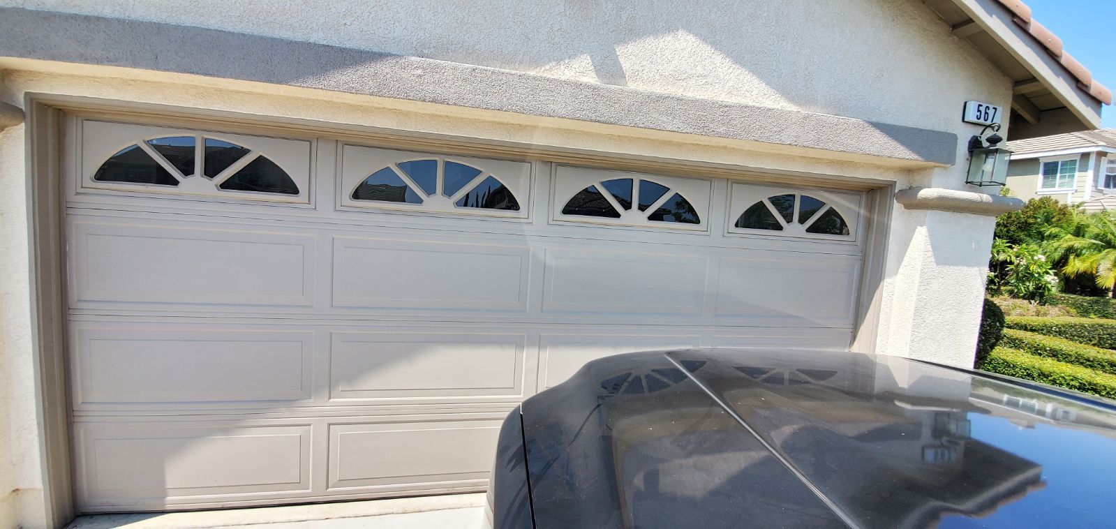 A car is parked in front of a garage door.