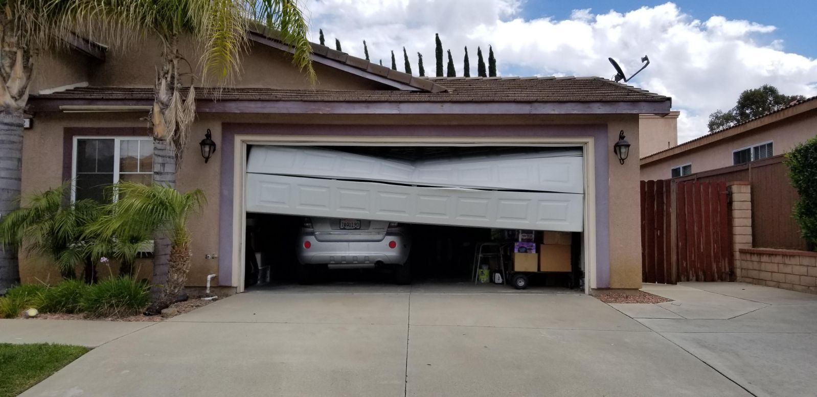 A car is parked in a garage with the door open.