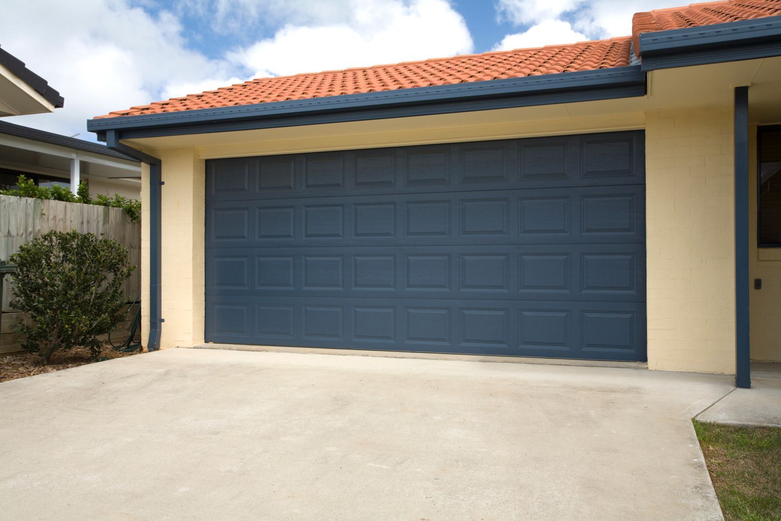 A house with a blue garage door and a red roof