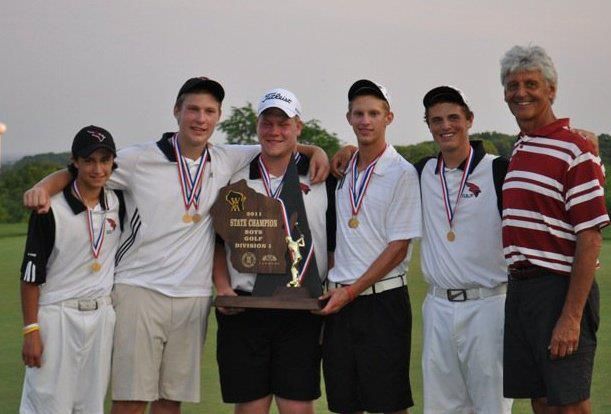 A group of men are posing for a picture while holding a trophy