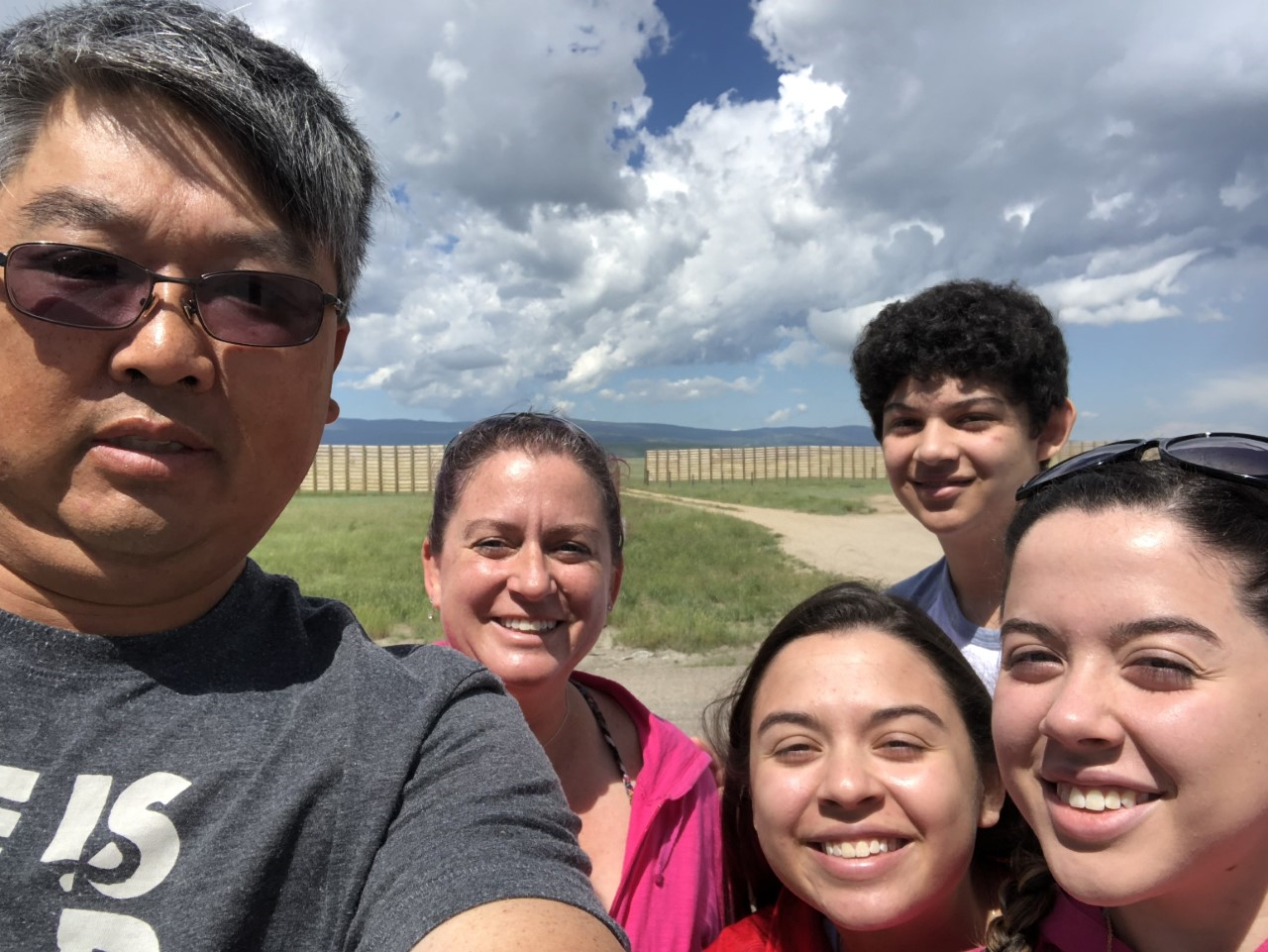 A group of people are posing for a selfie in front of the ocean.