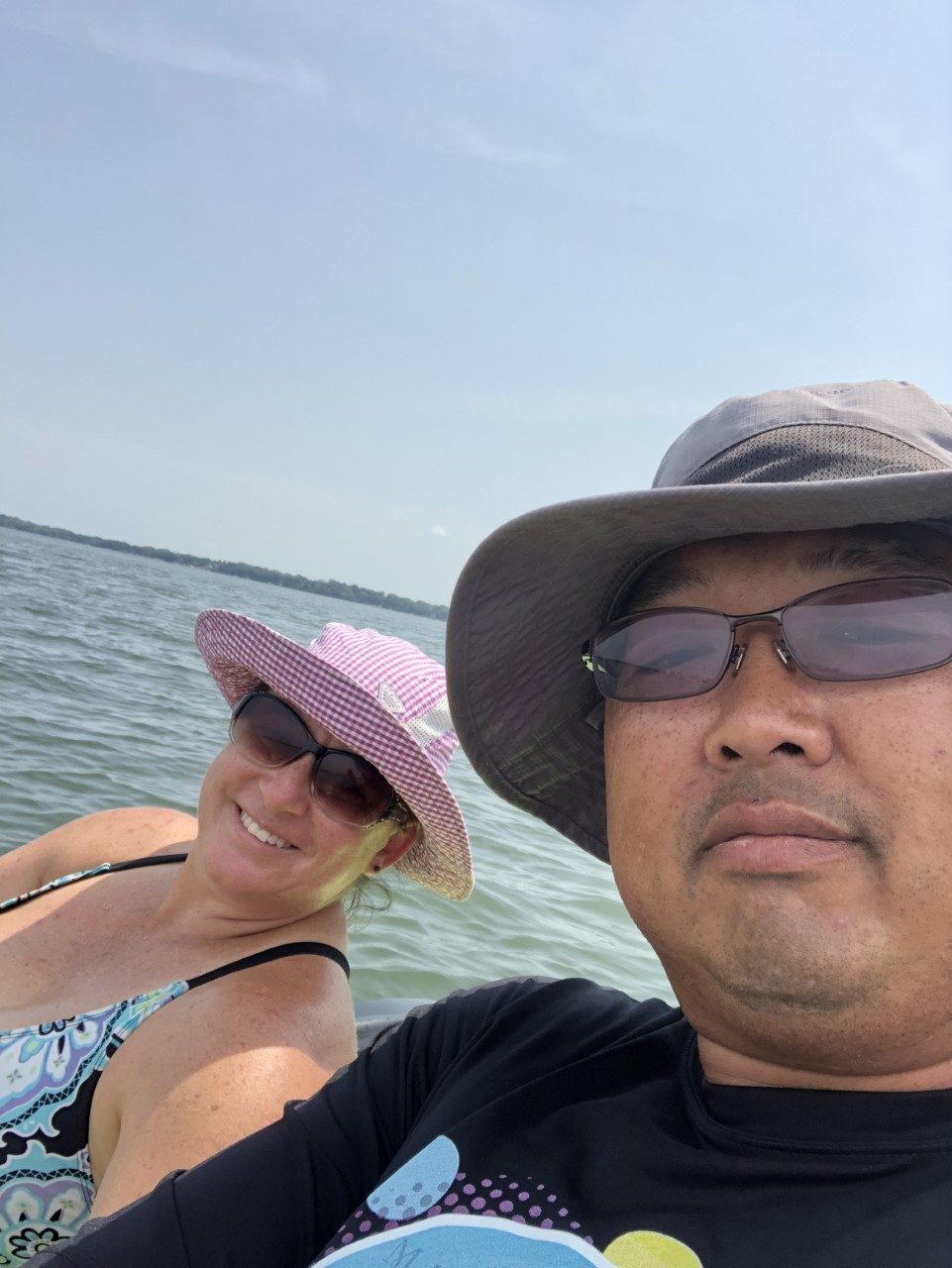 A man and a woman are taking a selfie in the water