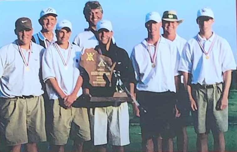 A group of men are posing for a picture with a trophy that says x on it