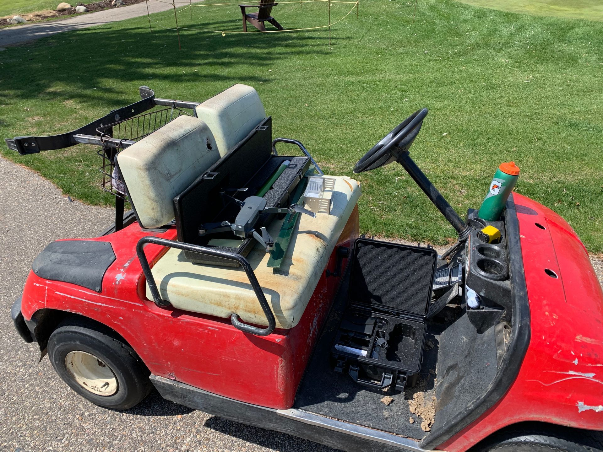 A red golf cart is parked on the side of the road.