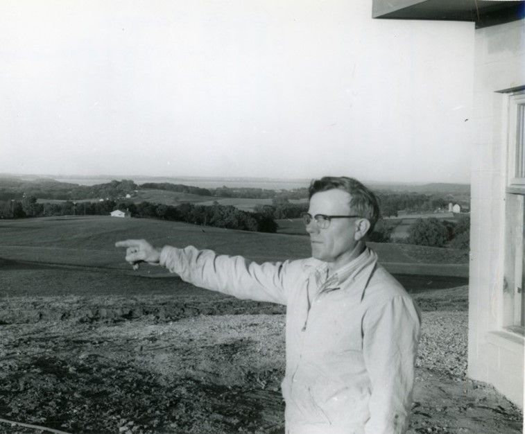 A black and white photo of a man pointing at something