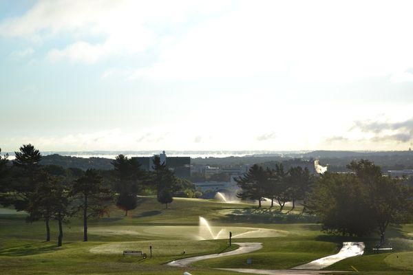 A view of a golf course with a fountain in the middle of it.
