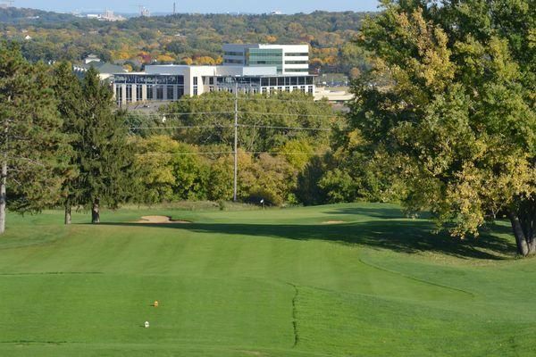 A golf course with trees and a building in the background.