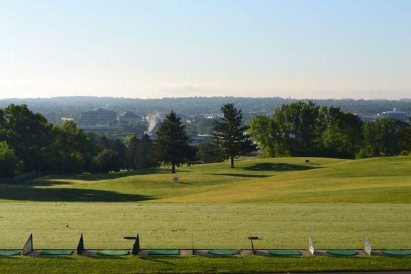 A view of a golf course with a city in the background