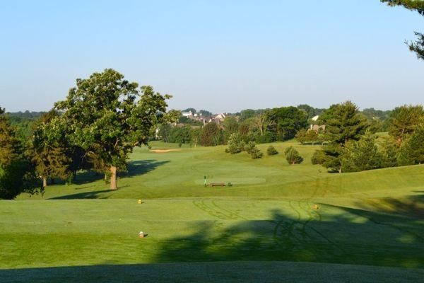 A golf course with trees and houses in the background