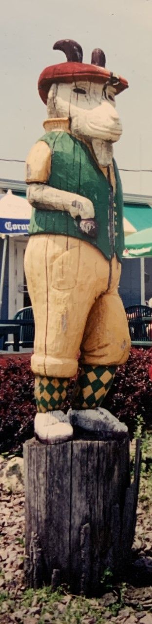 A statue of a man standing on a tree stump