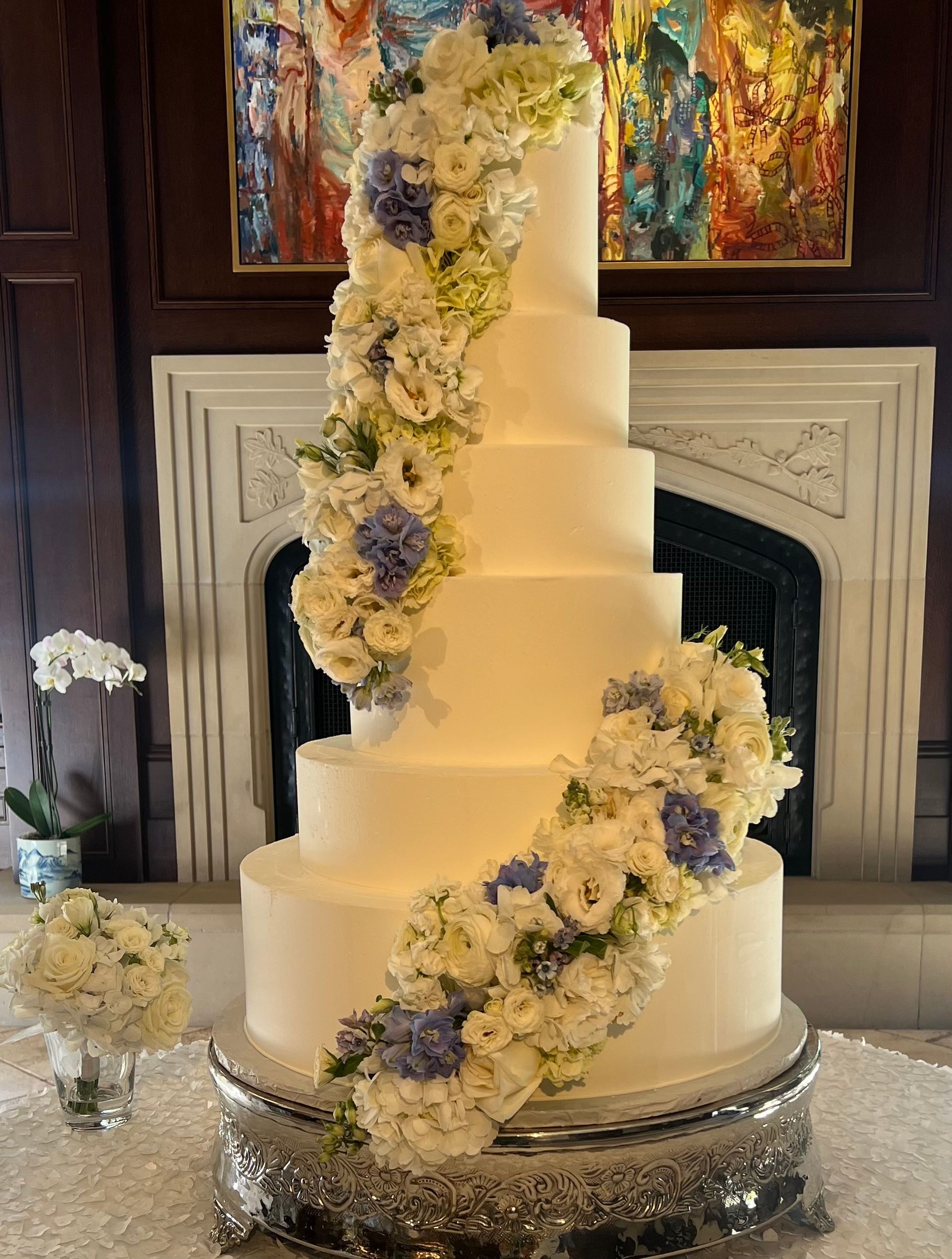 a white wedding cake with blue and white flowers on it