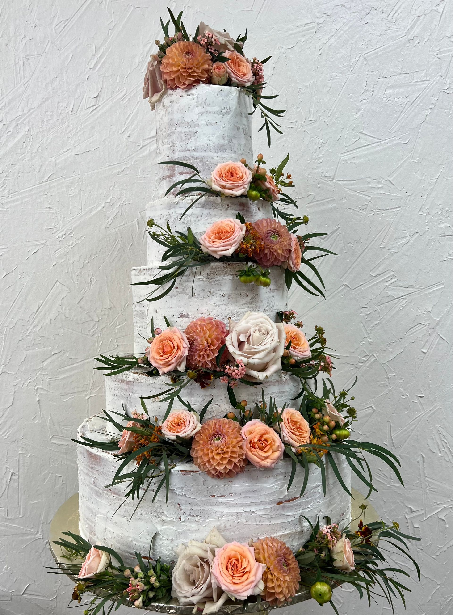 a wedding cake with flowers on it is sitting on a table .