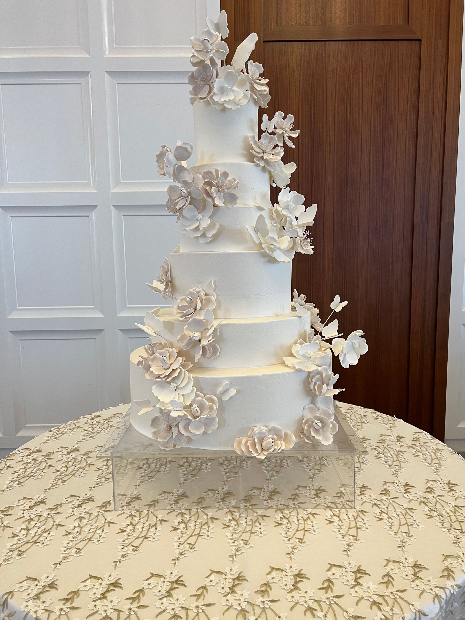a wedding cake is sitting on a table with a white table cloth .