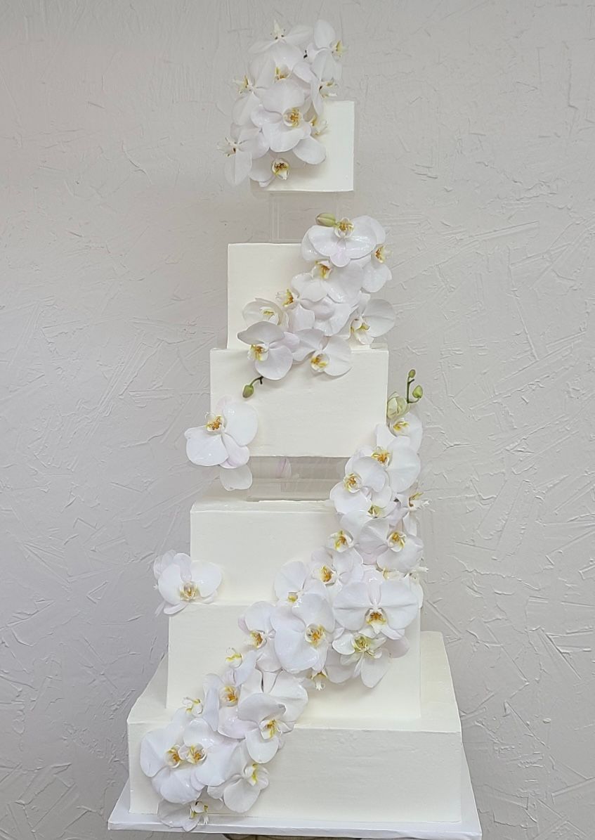 a white wedding cake with white flowers on it .