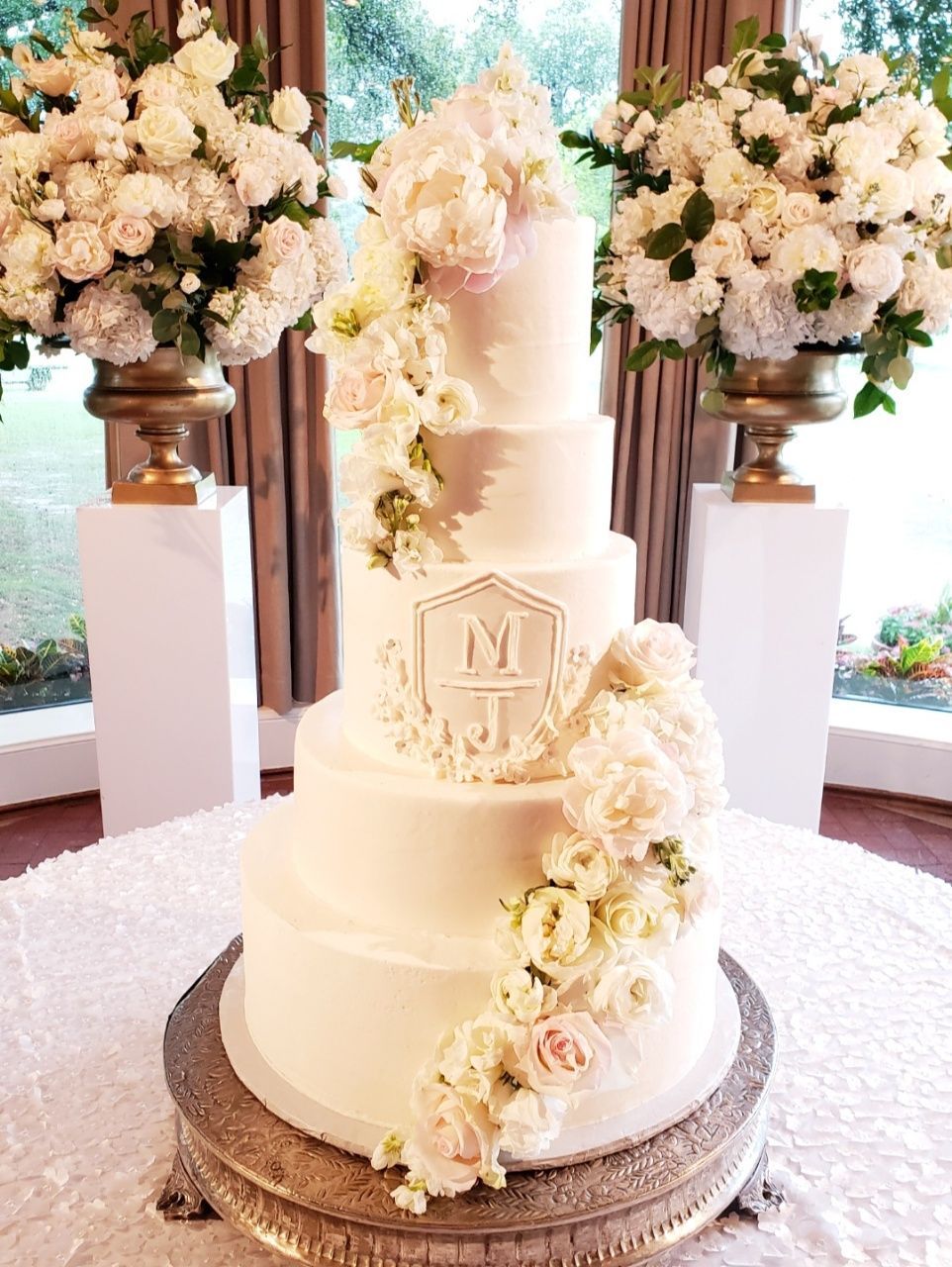 a wedding cake is sitting on top of a table next to vases of flowers .
