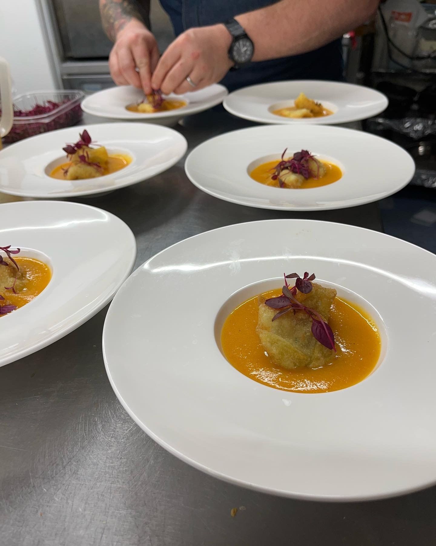 A man is preparing plates of food on a counter.