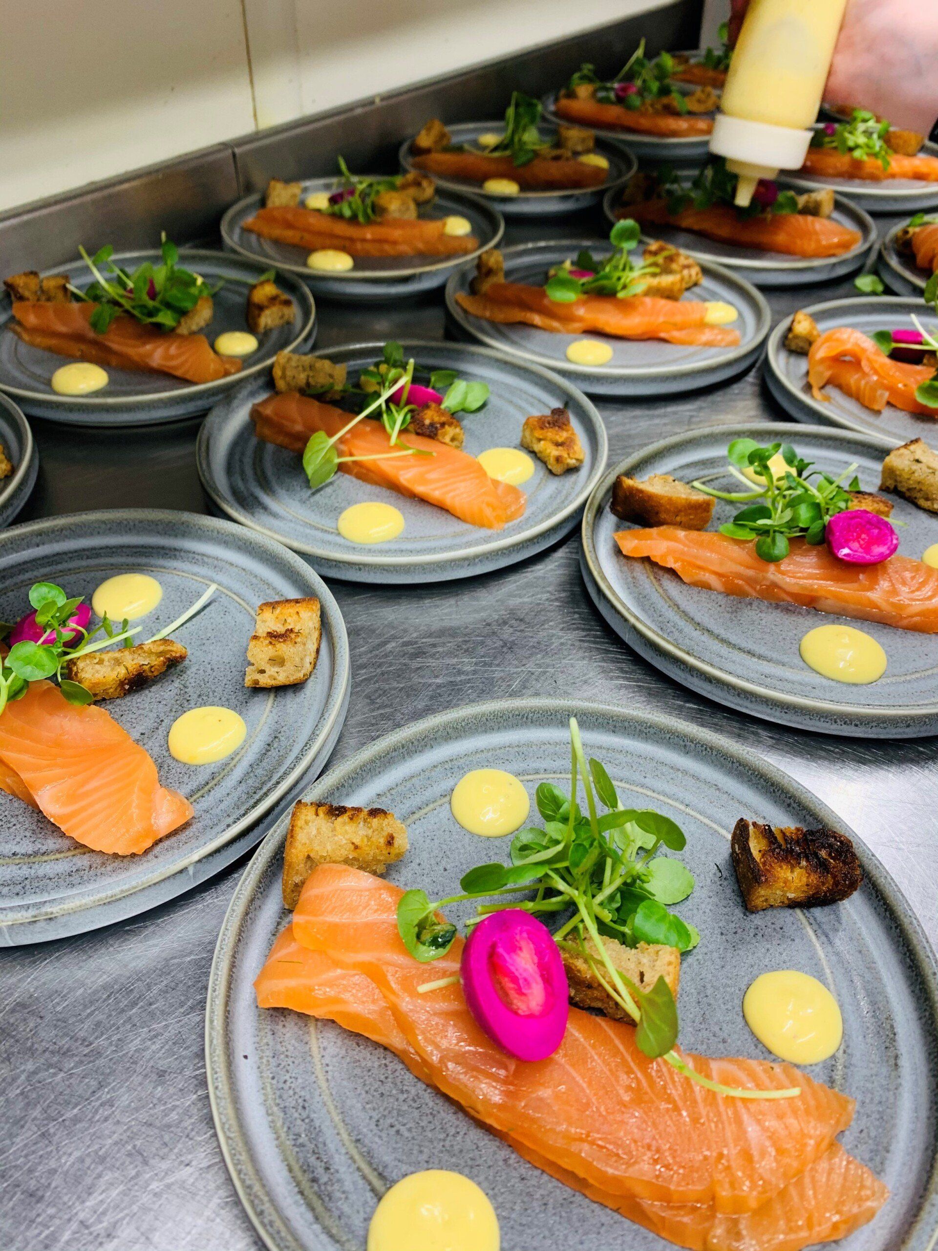 A person is pouring sauce on a plate of food.