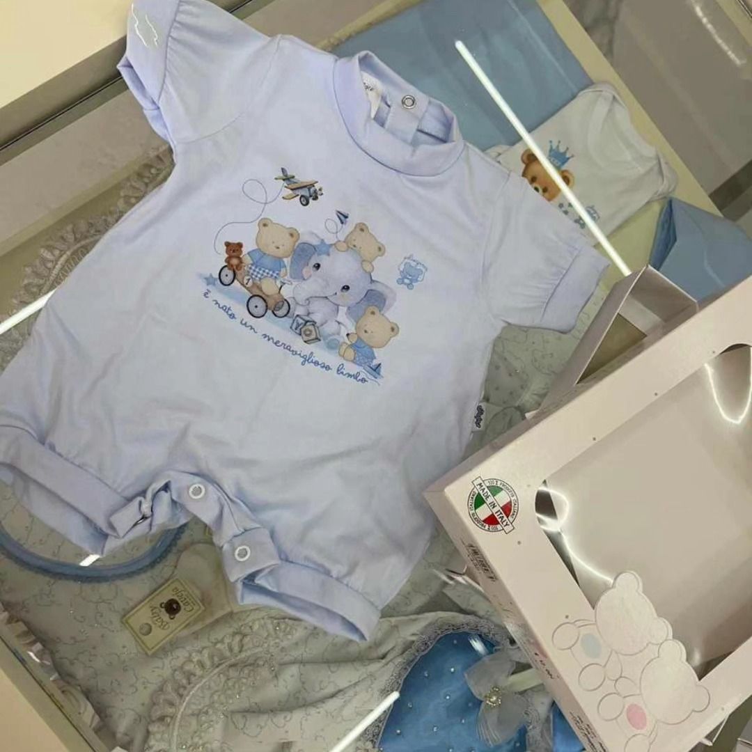 Una maglietta da neonato con uno strascico e degli orsetti sopra
