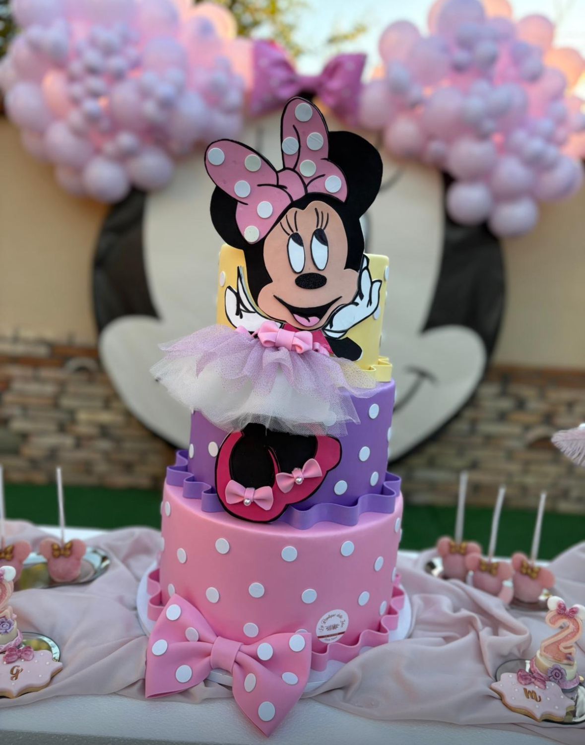 Una torta rosa e viola con Minnie Mouse sopra