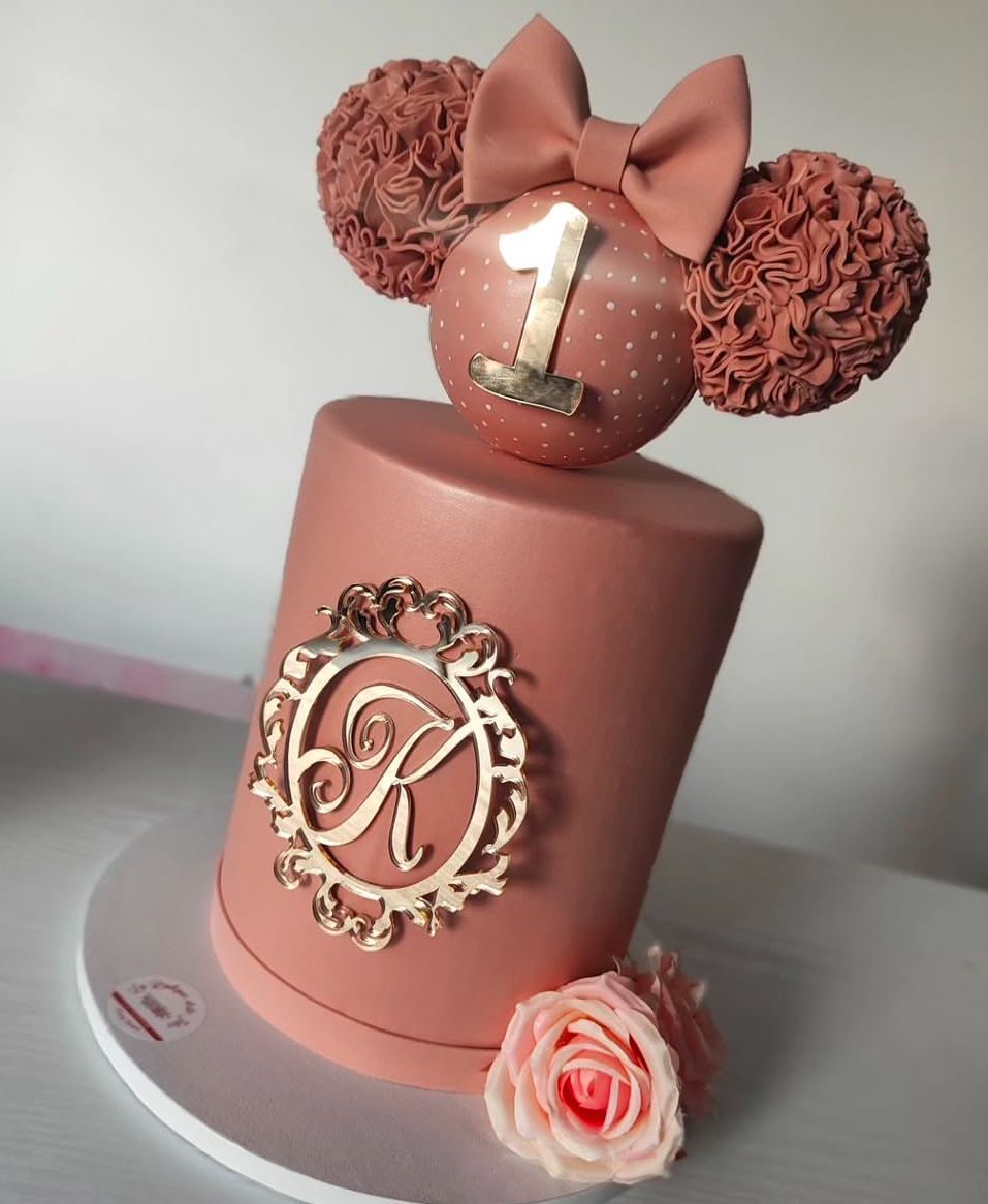 Una torta rosa con la lettera k sopra