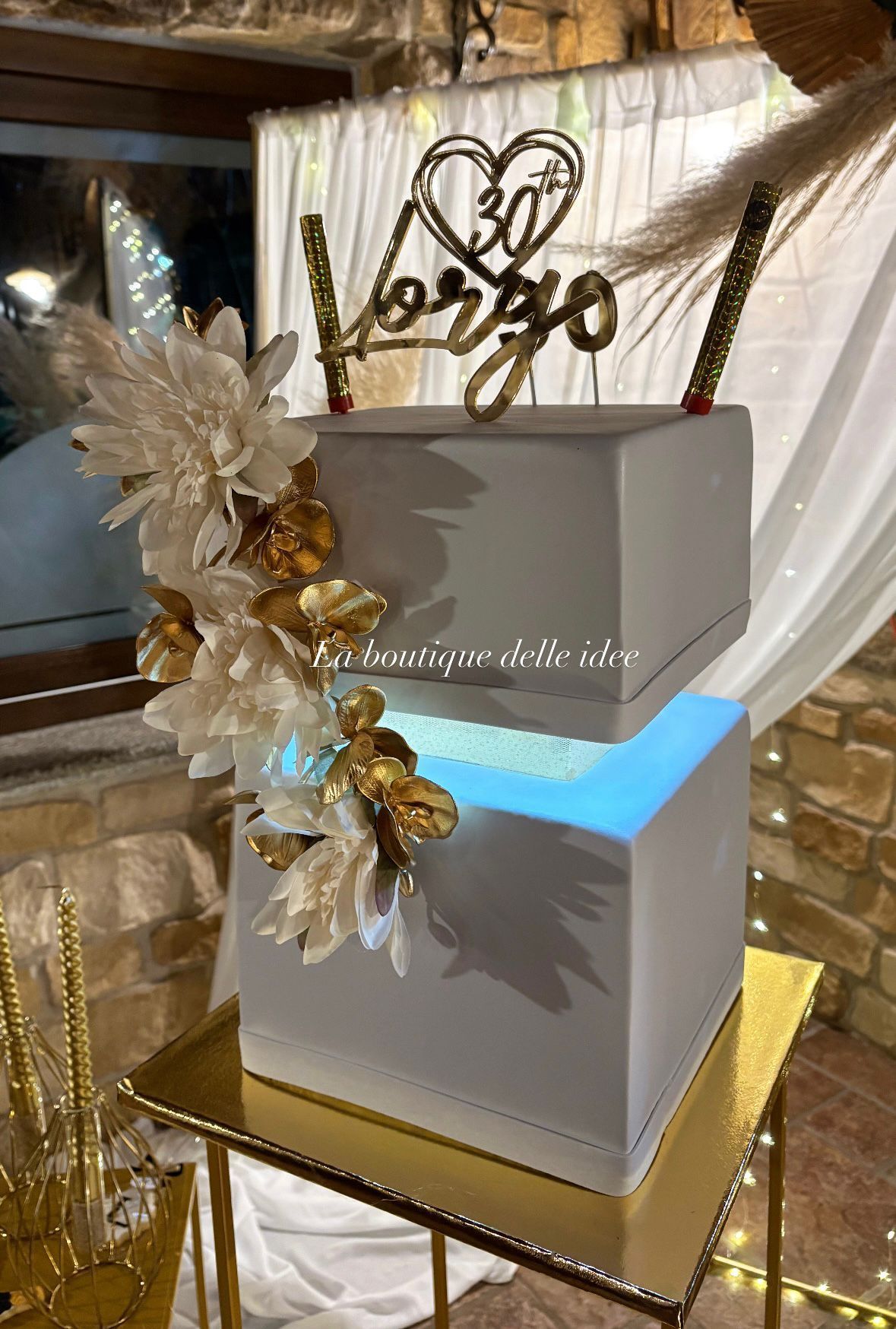 Una torta bianca è appoggiata su un tavolo dorato.