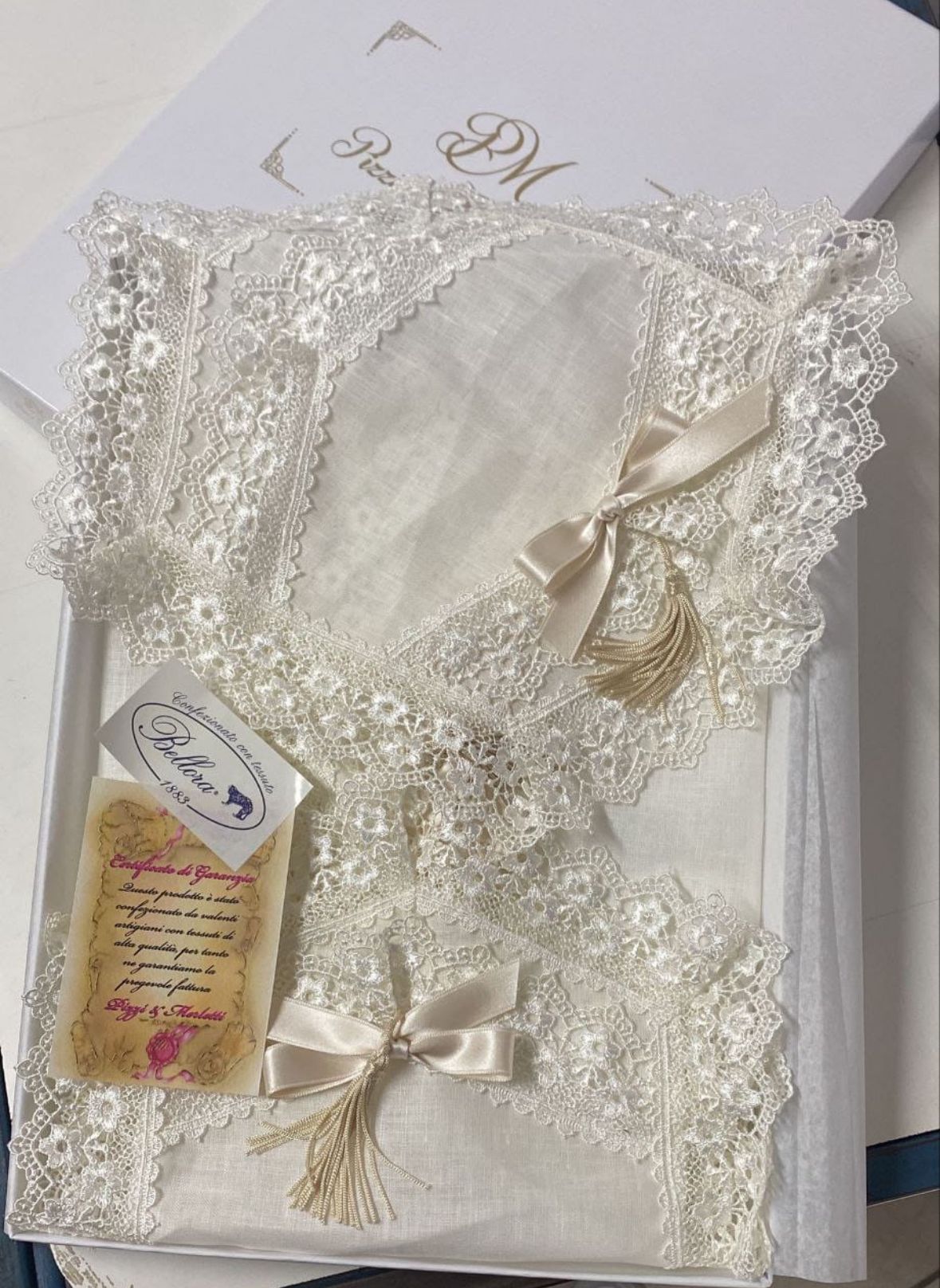 Un abito di pizzo bianco è appoggiato in una scatola bianca.