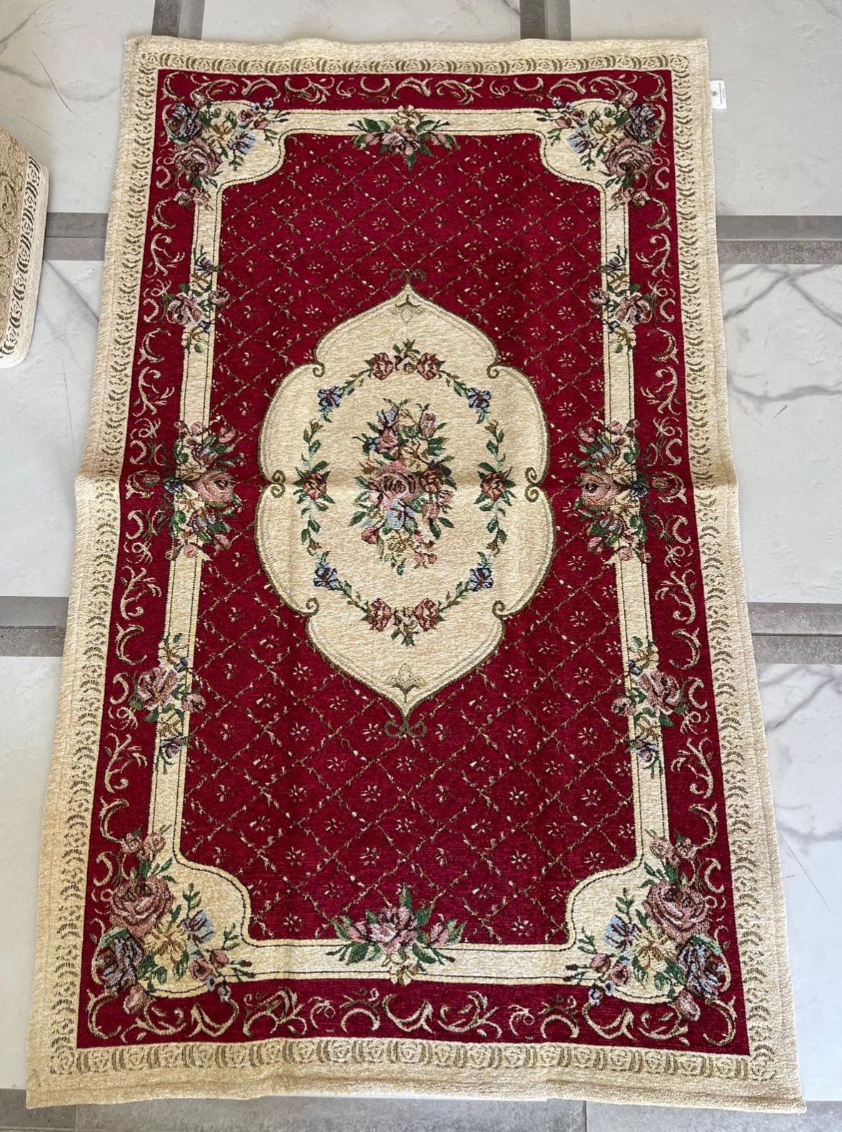 Un tappeto rosso con un motivo floreale è appoggiato su un tavolo.