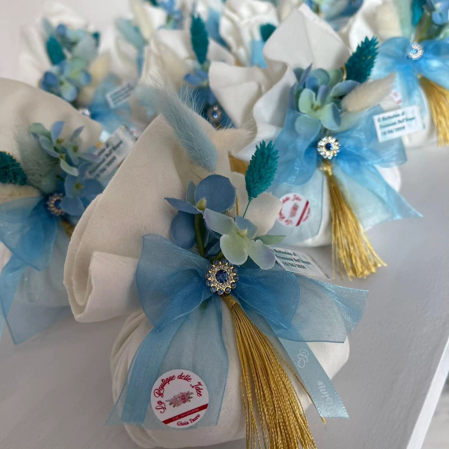 Una fila di scatole bianche con fiori blu e nappe