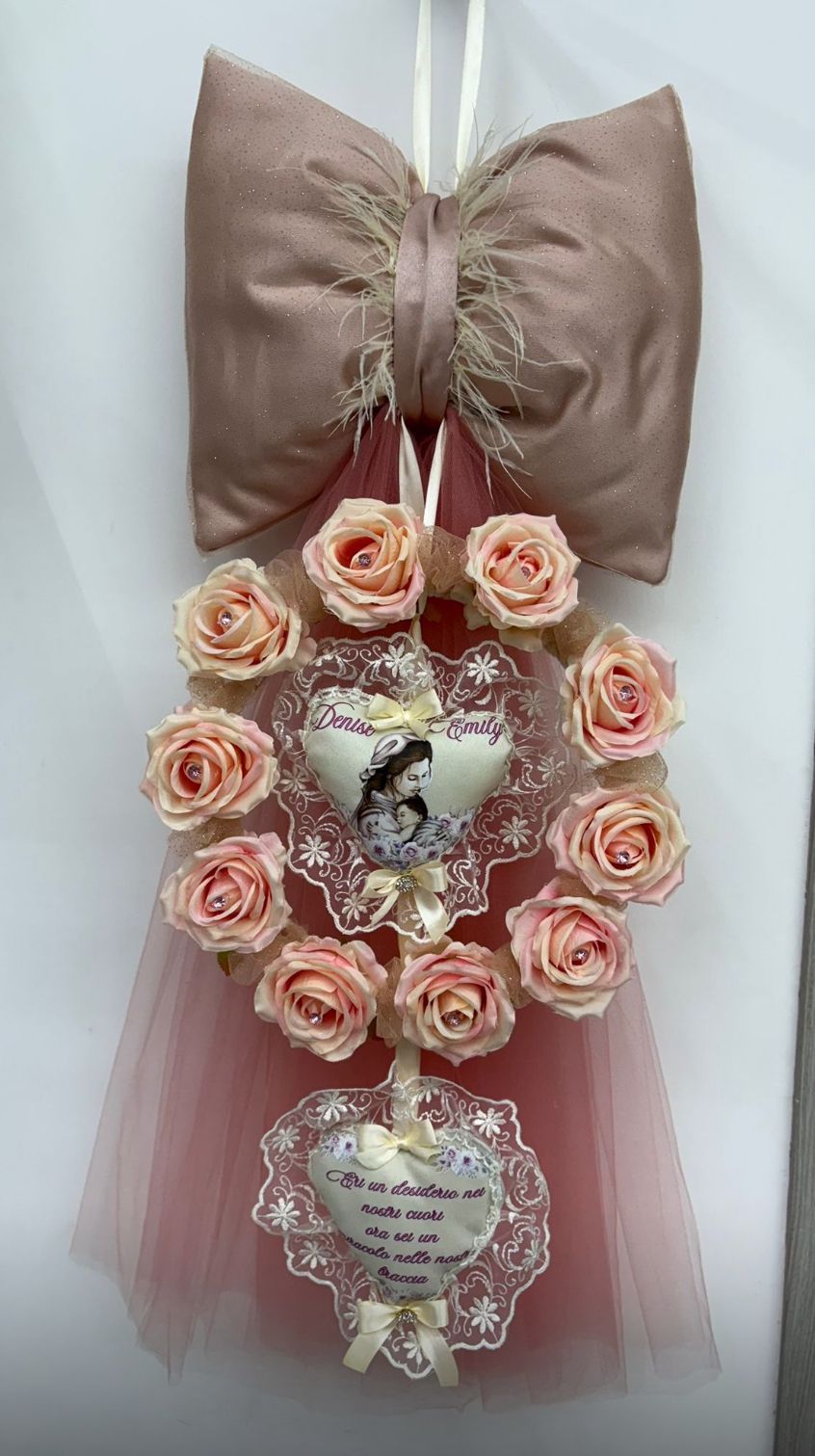 Una corona di rose e un fiocco è appesa a una parete.