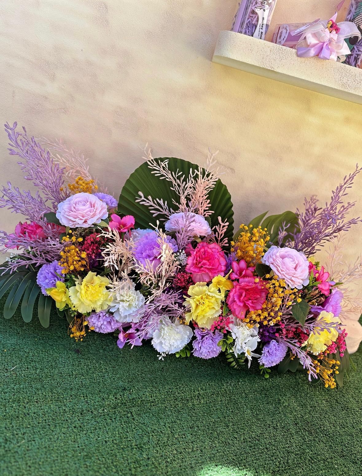 Un mazzo di fiori è posto in cima a un lussureggiante campo verde.