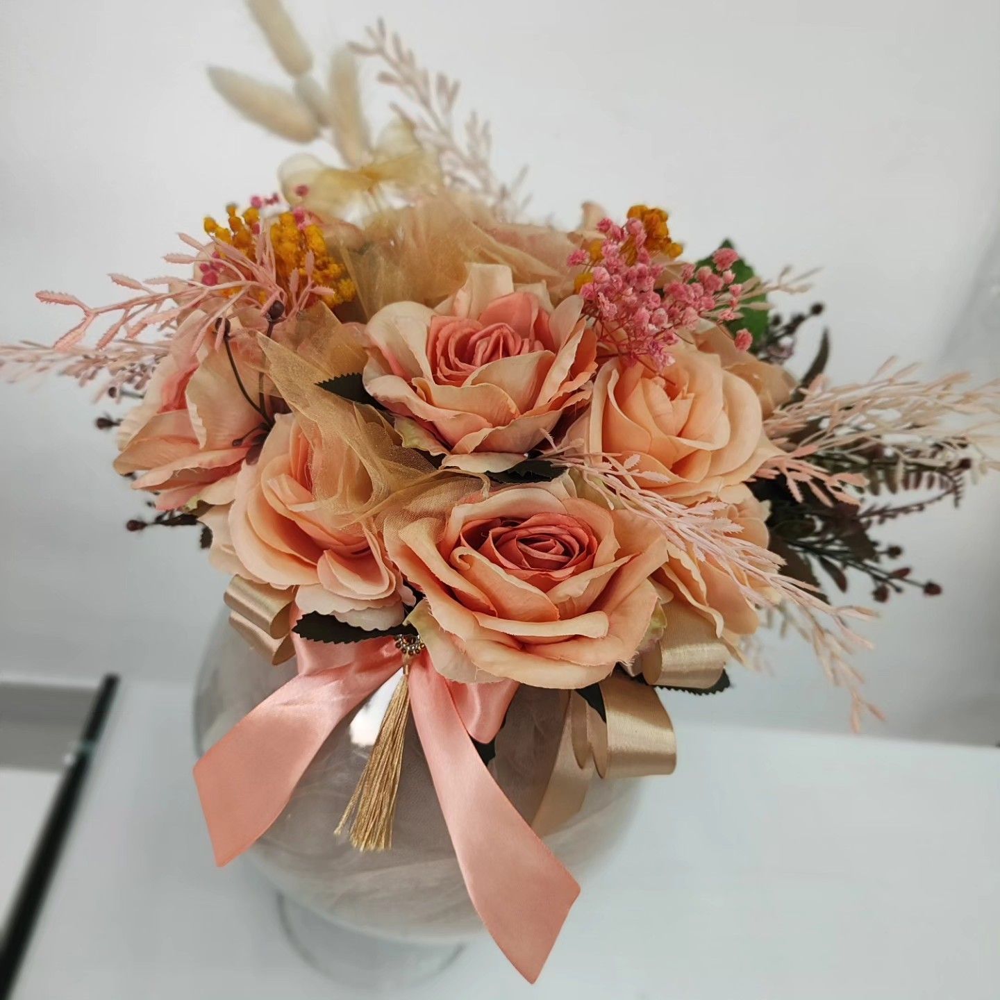 Un vaso pieno di rose rosa e altri fiori