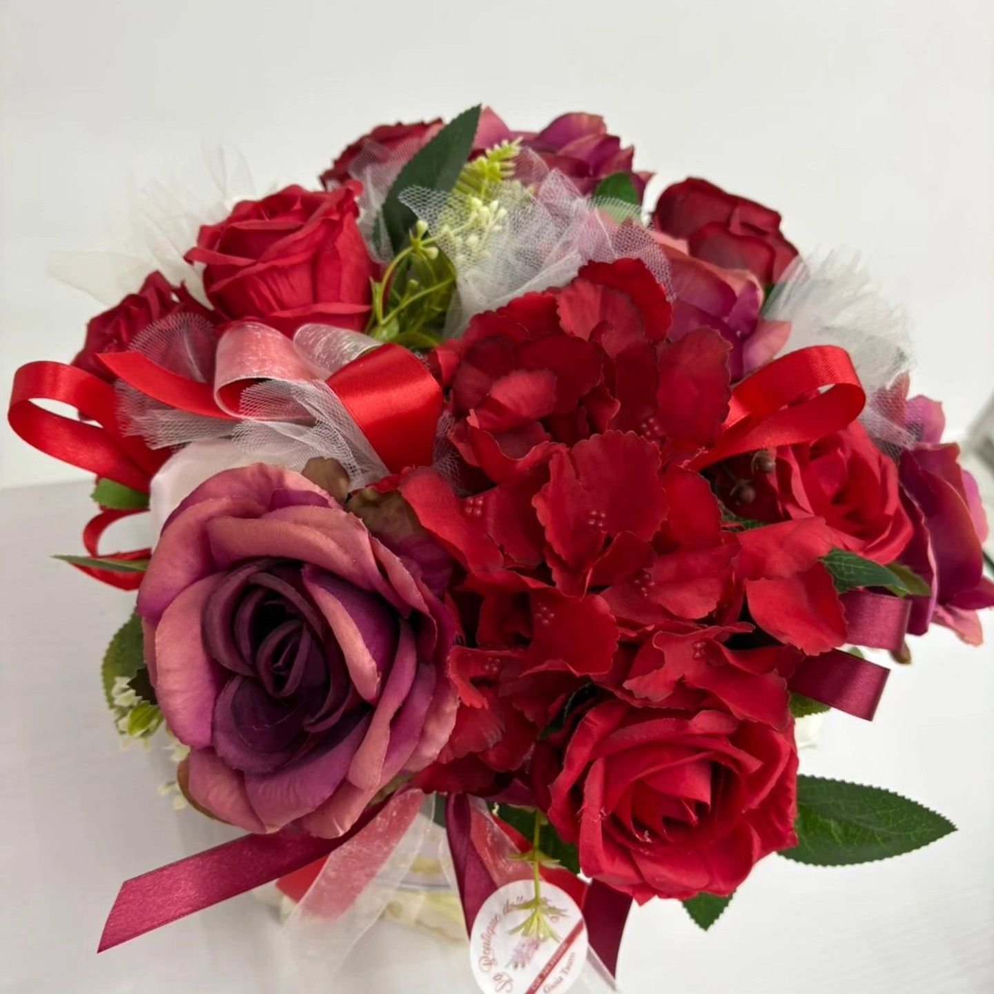 Un mazzo di rose rosse e fiori viola