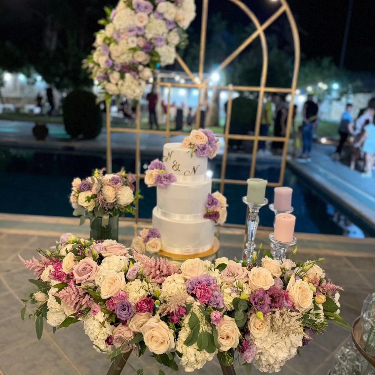 Una torta nuziale è posta su un tavolo circondata da fiori e candele.