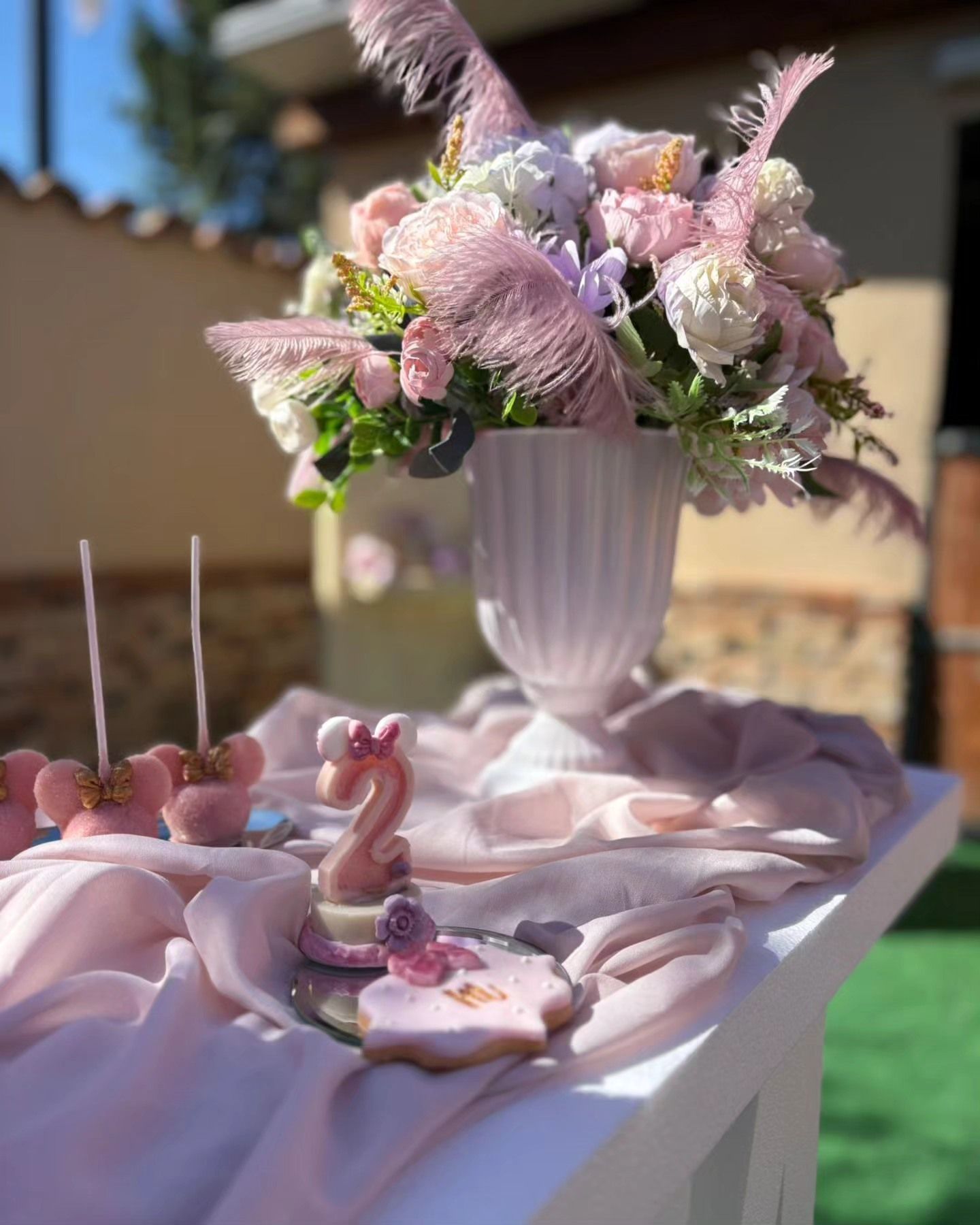 Un tavolo con sopra un vaso di fiori e biscotti.