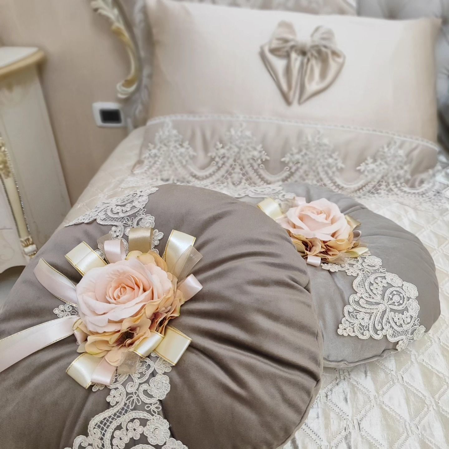 Due cuscini con fiori e pizzo sopra sono su un letto