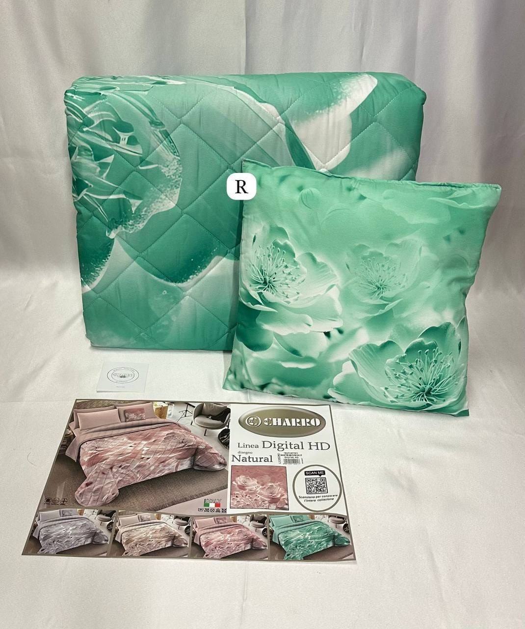 Una trapunta verde e due cuscini sono appoggiati su un tavolo.