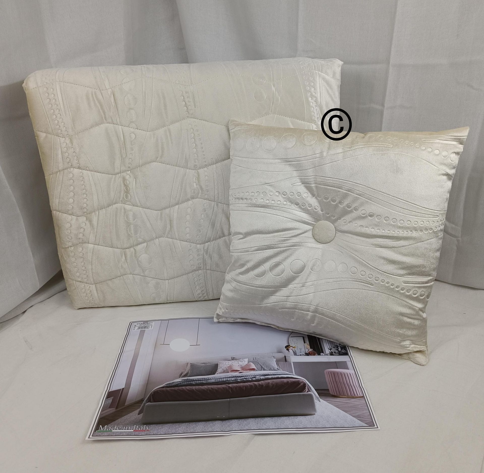 Tre cuscini bianchi sono appoggiati uno accanto all'altro su un letto