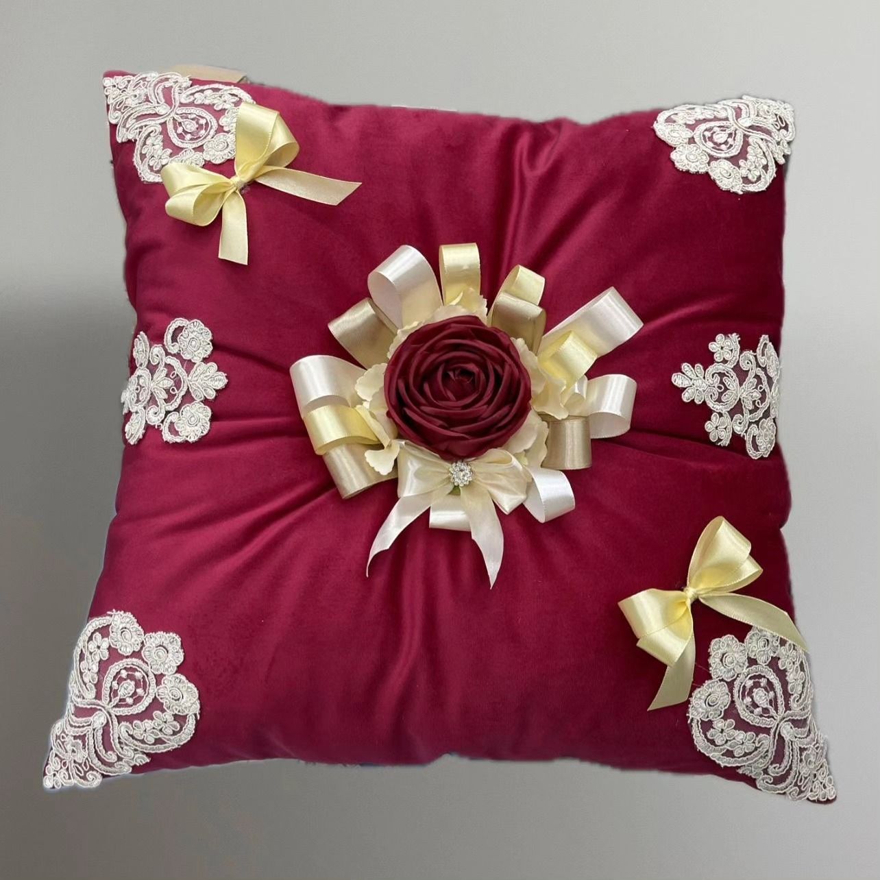 Un cuscino marrone con una rosa e dei fiocchi sopra