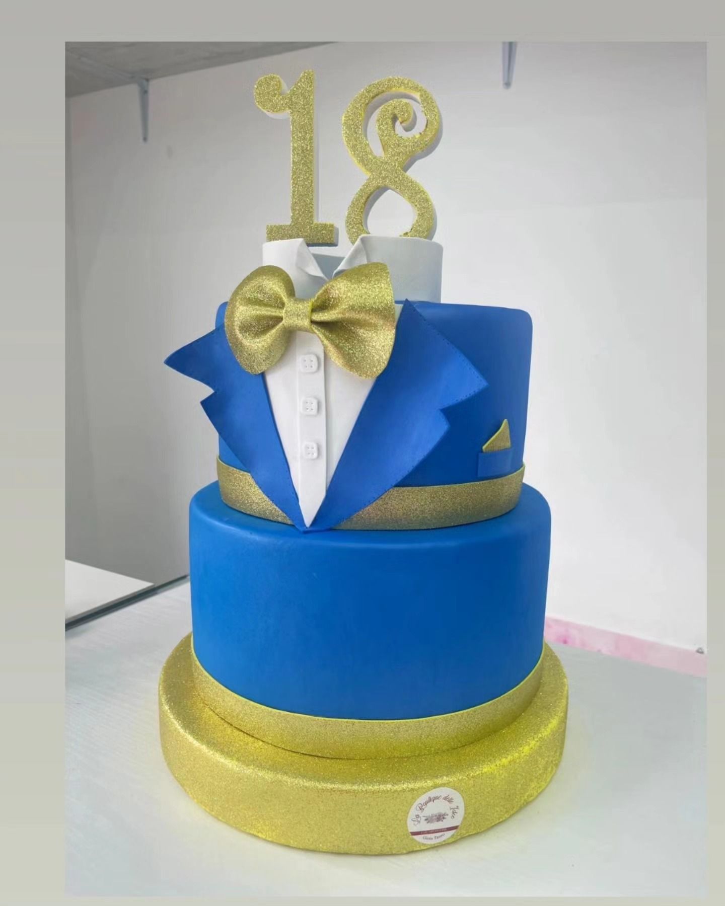 Una torta blu e oro con il numero 18 in cima