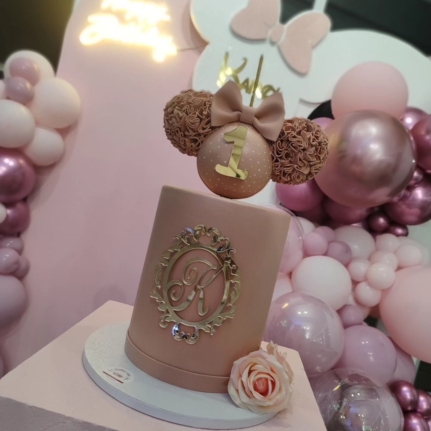 Una torta rosa con le orecchie di Topolino e il numero 1 sopra