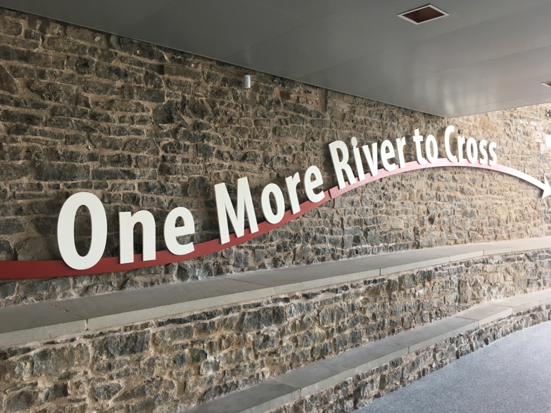 image of a brick wall that says 'One More River to Cross'
