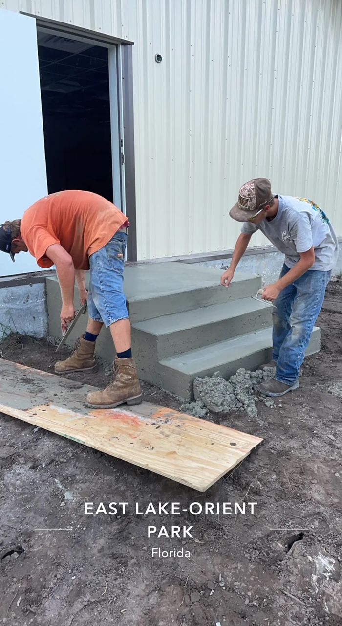 Two men building concrete steps at East Lake-Orient Park.