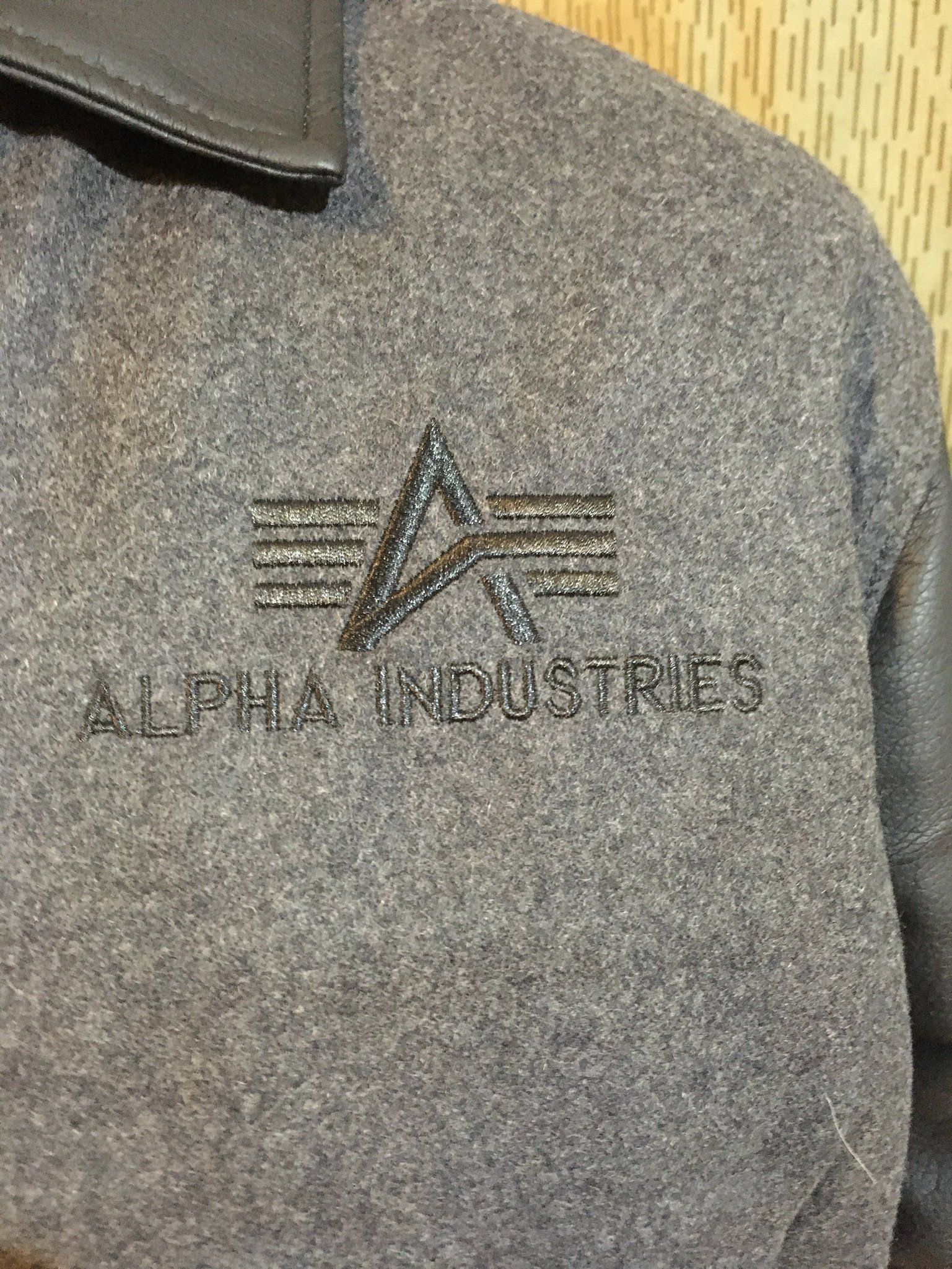 Graue Alpha Industries Jacke mit gesticktem Logo.