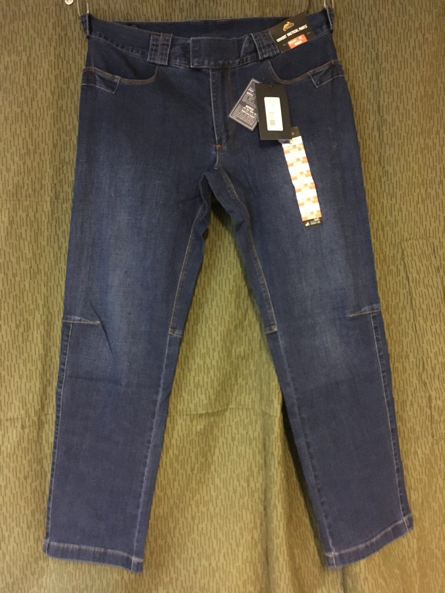 Dunkelblaue Jeans mit Kniepolstern und Preisschild.