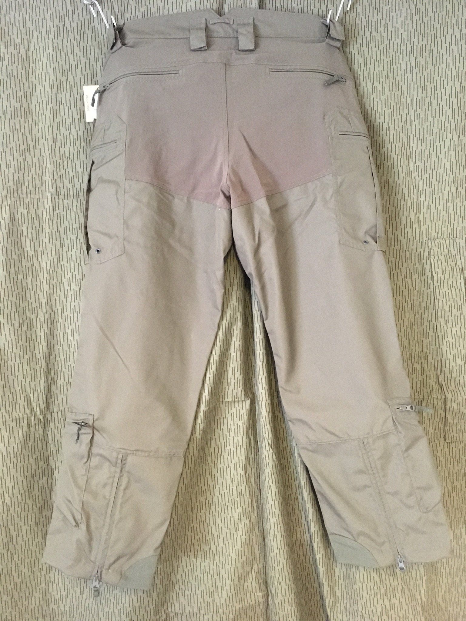 Hellbraune Skihose, die auf einem Kleiderbügel hängt, von hinten gesehen.