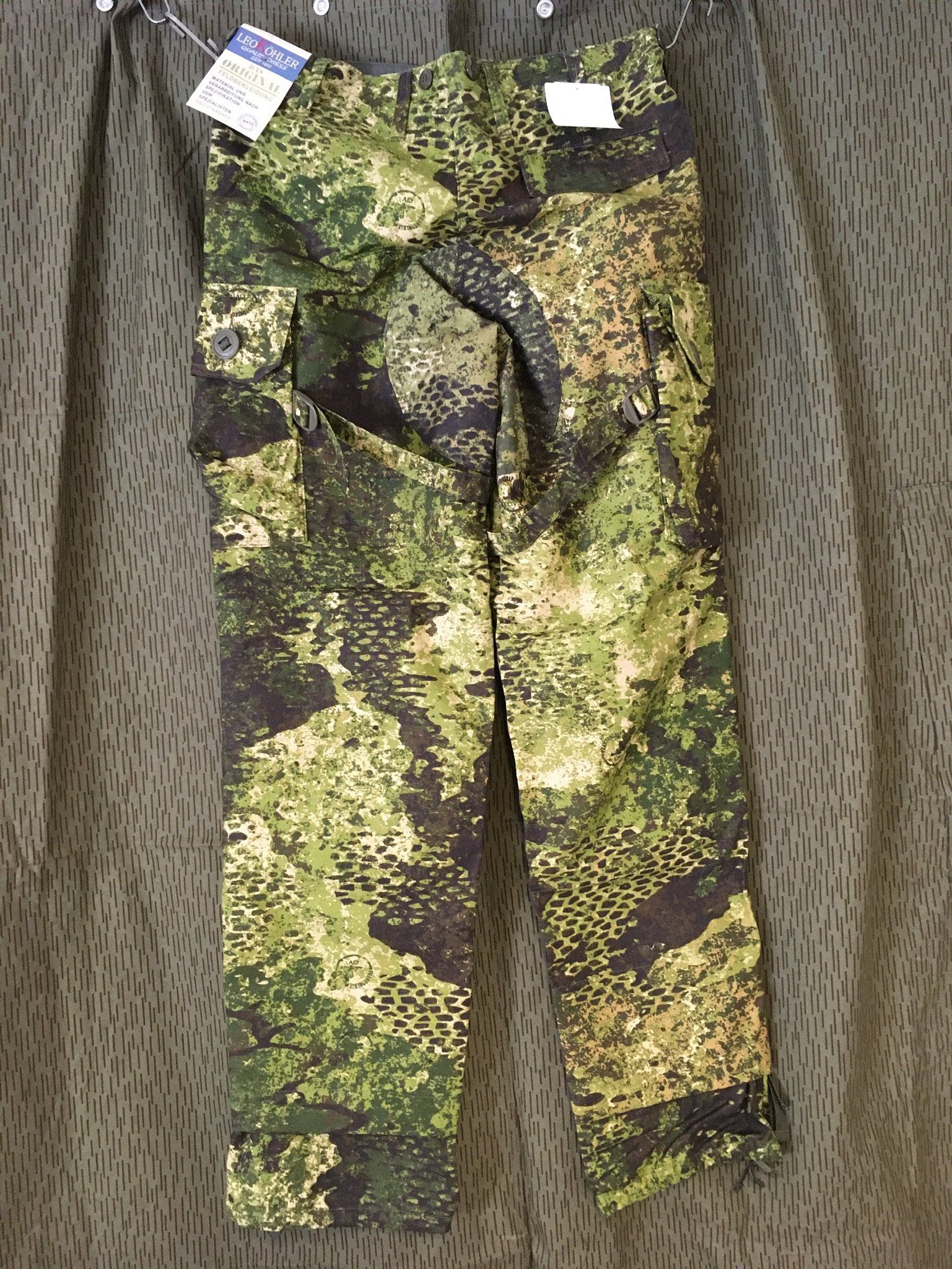 An einem Ständer hängen Tarnhosen in Grün-, Schwarz- und Brauntönen.