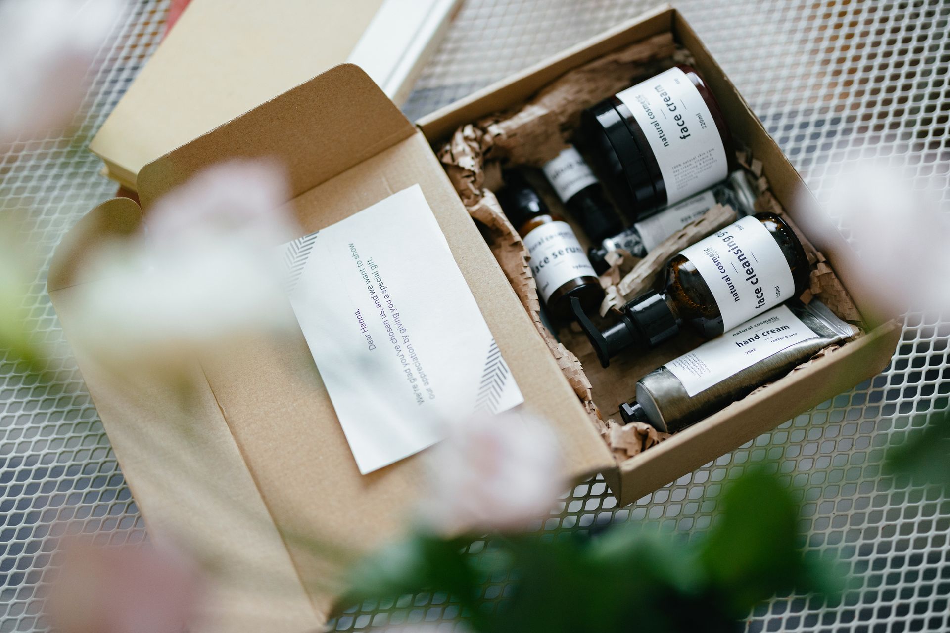 A box filled with bottles and a card on a table.