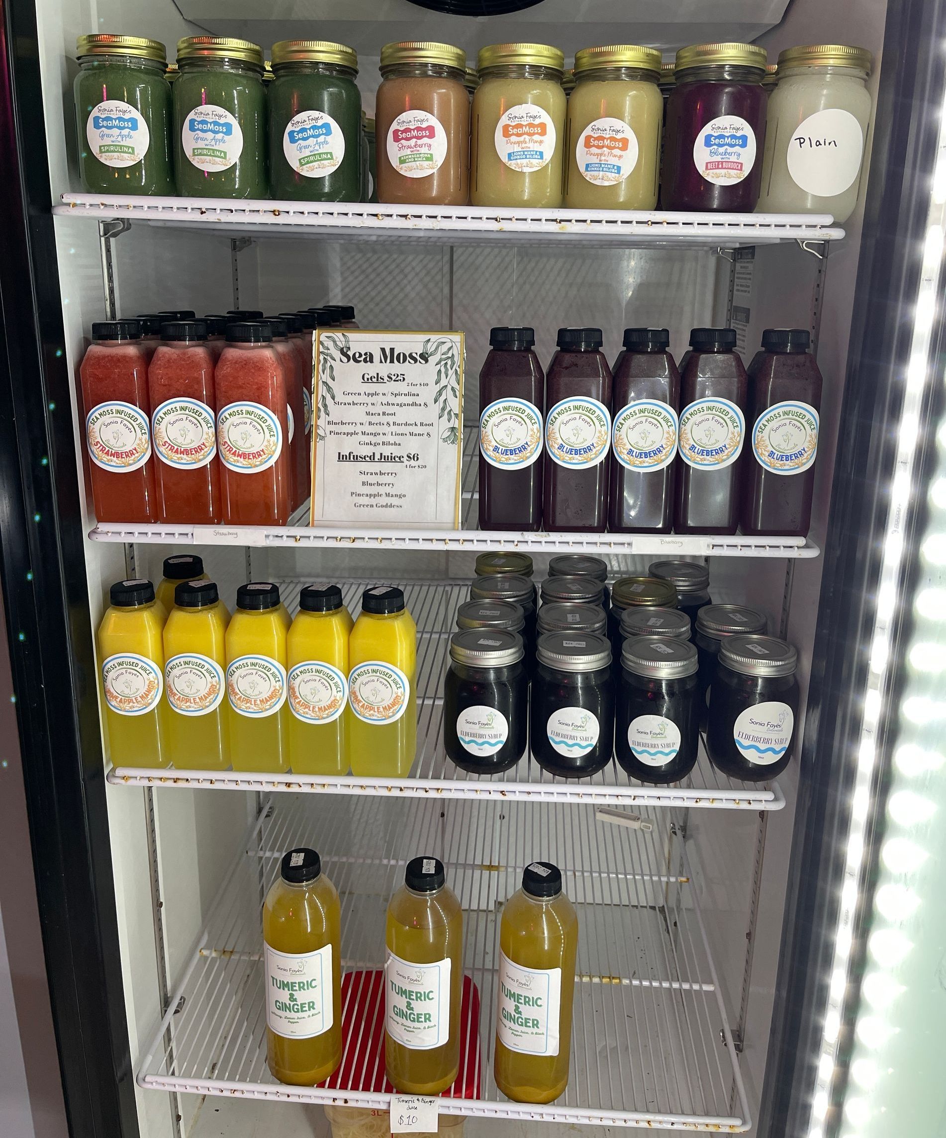 There are many different types of juices on the shelves.