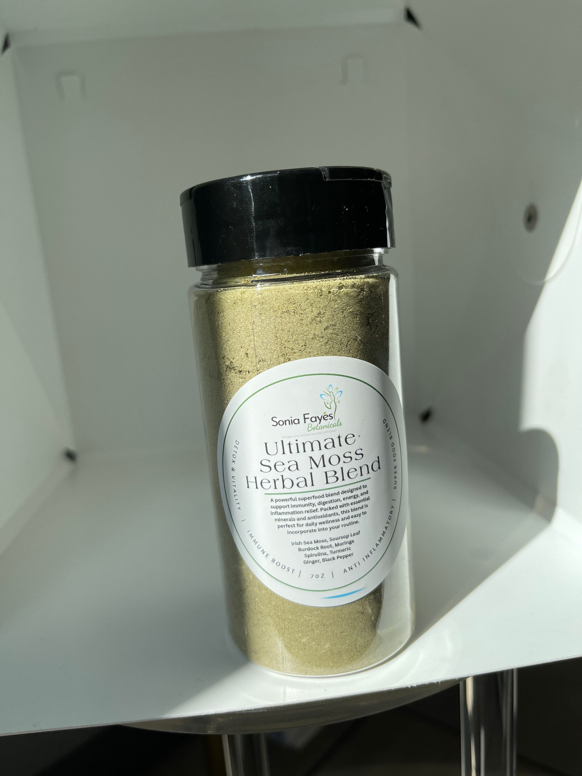 A jar of powder is sitting on a white shelf.